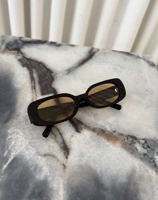Black frame sunglasses with brown lenses and squoval shape
