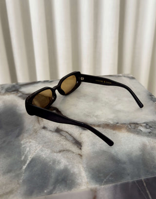 Black frame sunglasses with brown lenses and squoval shape