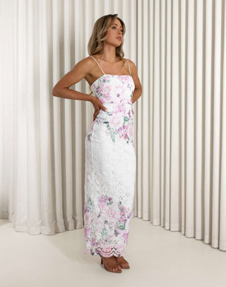 Woman wearing a floral dress standing against a white curtain background Aleyse floral lace maxi dress with back split