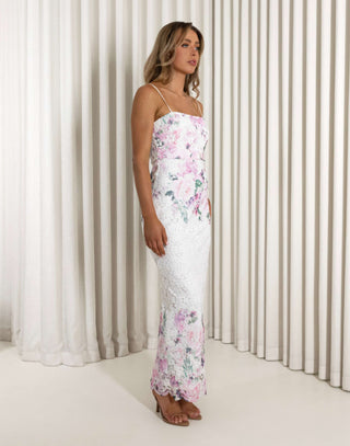 Woman wearing a floral dress standing against a white curtain background Aleyse floral lace maxi dress with back split