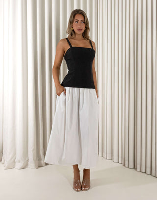 Woman wearing a black top and white pants against a white curtain background Amanda black and white two-tone midi dress with square neckline
