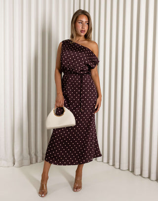 Woman wearing a polka dot dress against a white curtain background
Brown off shoulder midi dress with pale pink polka dots