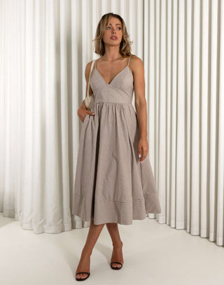 Woman wearing a gray dress standing against a white curtain background Emery brown fit and flare dress with flattering stripe placement