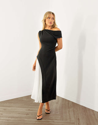 Woman wearing a black and white dress against a white wall. gavin-dress-off-one-shoulder-contrast-dress-monochrome