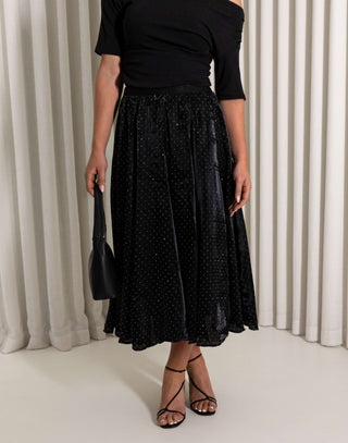 Black midi circle skirt with subtle sparkle worn by model
