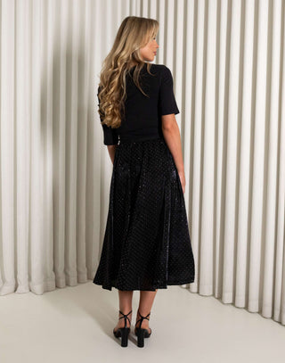 Black midi circle skirt with subtle sparkle worn by model
