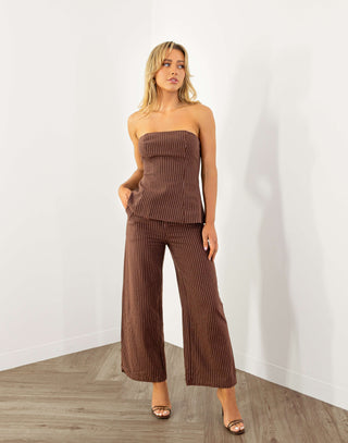 Model wearing strapless brown pinstripe top with shirred back