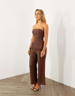 Model wearing strapless brown pinstripe top with shirred back