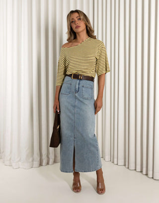 Woman wearing a striped yellow and white top and denim skirt against a white curtain background Martin stripe versatile off shoulder long length top