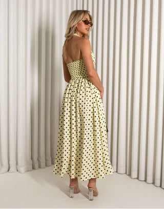 Yellow polka dot halter neck midi dress with pockets worn by model
