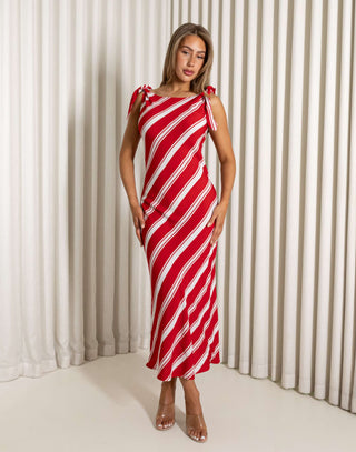 Woman wearing a red and white striped dress against a white curtain background Mike red and white striped bias-cut midi dress