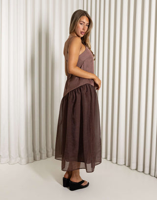 Woman wearing a brown dress standing against a white curtain background Nancy brown relaxed midi dress with adjustable straps
