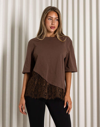 Woman wearing a brown top with lace detail against a neutral background Brown cotton t-shirt with lace hem detail