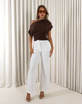 Woman wearing a brown off-shoulder top and white pants against a neutral background Nicole off shoulder gathered top in brown, fitted stretch
