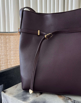 brown handbag on a marble surface with a neutral background