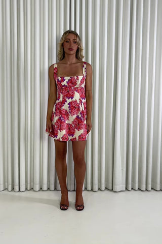 Woman wearing a floral dress against a white curtain background Billie floral mini dress with princess-seam bodice