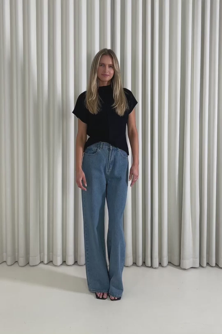 Model showing the Garrett Black Top and Benjy denim jeans from the front, side and back to demonstrate its fit and movement.