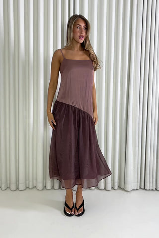 Woman wearing a brown dress standing against a white curtain background Nancy brown relaxed midi dress with adjustable straps