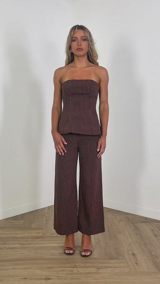 Model wearing strapless brown pinstripe top with shirred back
