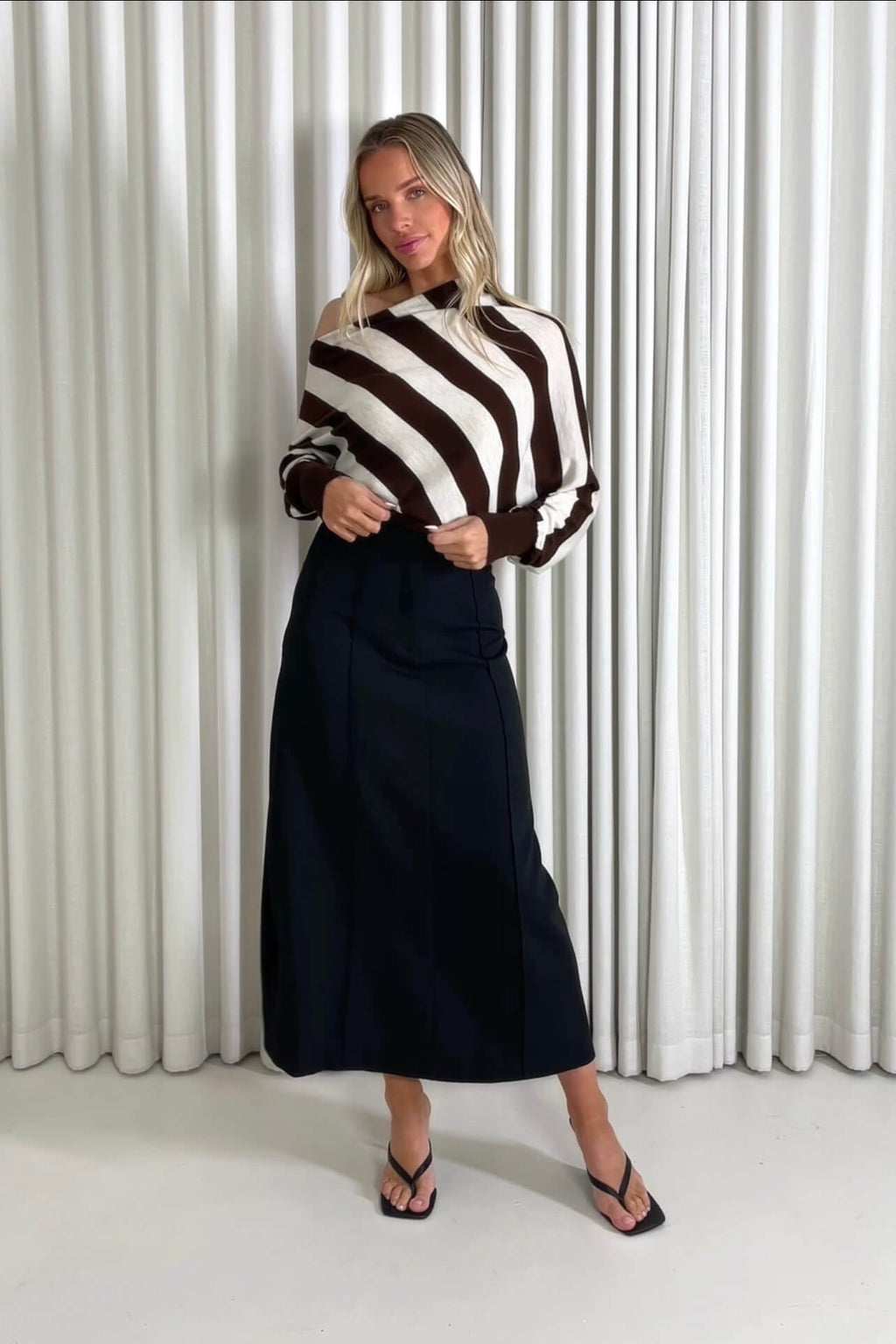 Model showing the Charles off-shoulder  top and Theresa black midi skirt from the front, side and back to demonstrate its fit and movement.