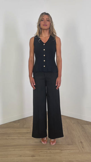 Black peplum knit top with statement buttons, bra friendly