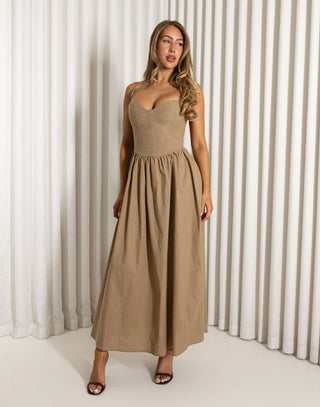 Woman wearing a long beige dress against a white curtain background Robin mocha fit-and-flare maxi dress with wireless cups
