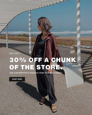 Woman standing by a modern architectural structure with ocean view, promotional text overlay.